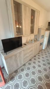 a living room with a television on a cabinet at Casa Leone in Stintino