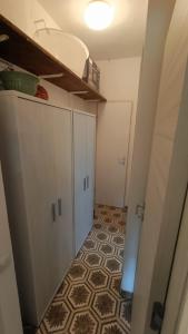 a room with a hallway with a kitchen with a floor at Casa Leone in Stintino