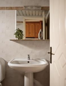 Un baño con un lavabo blanco y un espejo. en Avra Rooms, en Kerion