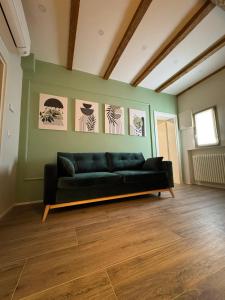 a living room with a black couch against a green wall at HouSmart Emilia 15 in San Lazzaro di Savena +29 photos