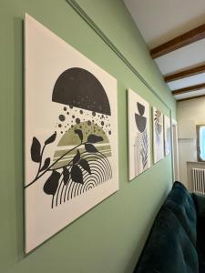 a living room with three paintings on the wall at HouSmart Emilia 15 in San Lazzaro di Savena