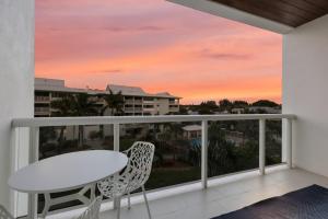a balcony with a table and chairs and a sunset at Ten35 Seaside Rentals in Siesta Key +291 photos