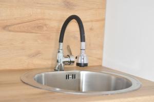 un fregadero de acero inoxidable en una encimera en Studio Dobra Voda 13, en Dobra Voda 9 fotos más