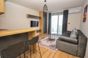 una sala de estar con un sofá y una silla en Studio Dobra Voda 13, en Dobra Voda