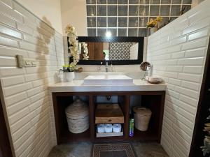 a bathroom with a sink and a mirror at Kampung Kecil Beach Front Boutique Hotel in Kubu