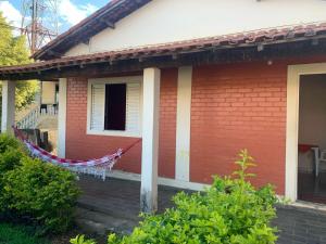 a red house with a hammock hanging from it at Casa de Temporada in São Lourenço