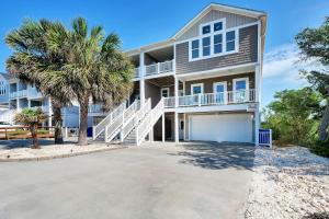Walk to Beach Oak Island Retreat with 210-Yard Dock في أوك آيلاند: منزل كبير أمامه أشجار نخيل