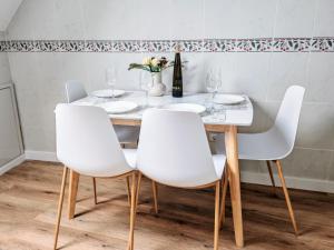 a dining room table with four white chairs and a white table at Peralto Playa in Boiro +17 photos
