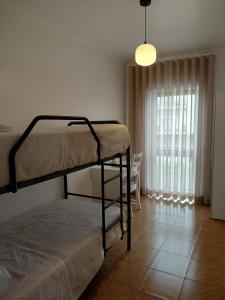 ein Schlafzimmer mit zwei Etagenbetten und einem Fenster in der Unterkunft Vila Morena in Grândola + 1 Foto