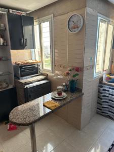 a kitchen with a counter and a clock on the wall at Ahmed 205 in Temara +9 photos