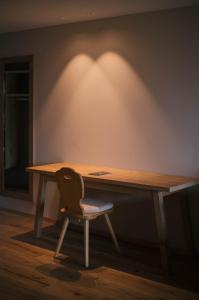 a desk with a chair in front of a wall at Boutique Hotel Pachers in Bressanone