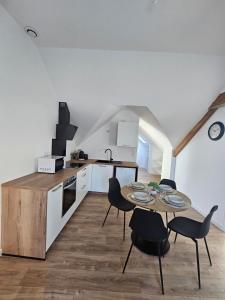 a kitchen and dining room with a table and chairs at L'Authentique, Appartement 7 in Loudéac +9 photos