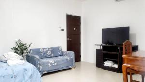 a living room with a chair and a television at Bann Sawasdee Donmueng- Saimai หลังใหญ่ ฟรี wifi in Ban Sai Mai