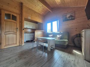 a kitchen and living room with a table and a couch at Ostoja Rodzinna in Giżycko