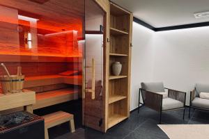 a room with a wooden cabinet and a chair at Chalet Mädesüss in Weitnau