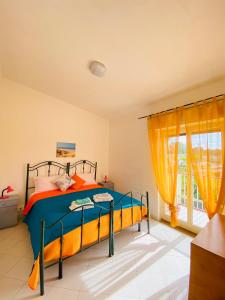 a bedroom with a bed and a window at Appartamento Fronte Mare Marzamemi in Marzamemi