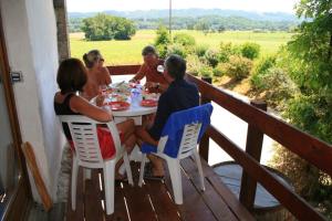eine Gruppe von Menschen, die an einem Tisch auf einer Veranda sitzen in der Unterkunft Naturist Hotel Peyraille in Libaros