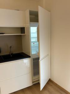 Una cocina con gabinetes blancos y un fregadero. en Verde Acqua Suite, en Lecco 25 fotos más