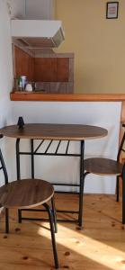 a wooden table with two chairs and a kitchen at Apartments Elena & Damir in Vis