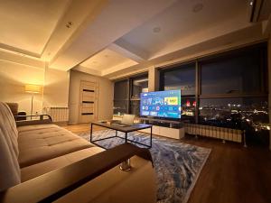 a large living room with a couch and a television at F1 Track view by Bakuapart in Baku +10 photos