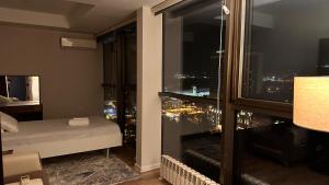 a bedroom with a view of a city at night at F1 Track view by Bakuapart in Baku
