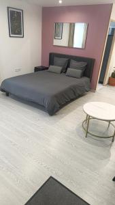 a bedroom with a large bed and a table at Grand studio dans maison parking privé gratuit in Eschentzwiller