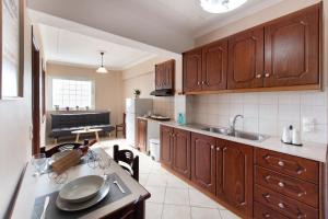 a kitchen with wooden cabinets and a table in it at Sunrise studios Lefkada in Nydri