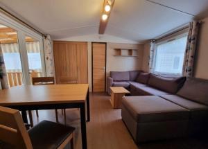 un salon avec un canapé et une table dans l'établissement LOCATION MOBIL HOME 40m carré de 2 à 8 personnes en bords de mer, à Saint-Brévin-lʼOcéan