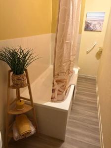 a bathroom with a bath tub with a plant in it at Maison de Rêve in Notre-Dame-du-Touchet