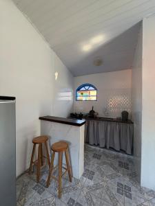 een keuken met een aanrecht en krukken in een kamer bij Kitnet Brava 2 in Búzios