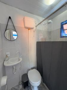 een badkamer met een toilet, een wastafel en een spiegel bij Kitnet Brava 2 in Búzios +10 foto's