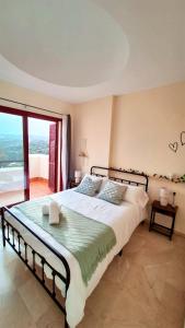 a bedroom with a large bed and a large window at Heaven's Door in Bahia de Casares
