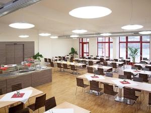 una clase con mesas y sillas en una cafetería en Campus Bad Kissingen, en Bad Kissingen