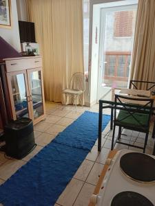 a living room with a blue rug and a table at La Maison de Natasha in Castillon-en-Couserans