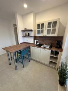 una cucina con un tavolo di legno e sedie blu di Drei Kirchenblick Ferienwohnung a Heilbad Heiligenstadt
