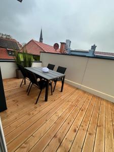 un patio con tavolo e sedie su un ponte di Drei Kirchenblick Ferienwohnung a Heilbad Heiligenstadt