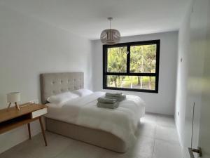 una camera da letto bianca con un letto e una finestra di Spacious Beach House in Malaga-Cala de Mijas, amazing see view, 3 bedroom, garden & Common Pool a Málaga Altre 16 foto