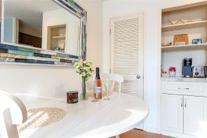 een witte eetkamer met een witte tafel en een spiegel bij Lovely Beachside Studio 5679 in Williamsburg
