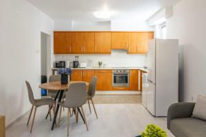 a kitchen with a table and a refrigerator at Cozy Sweet Hideaway Apartment in the Heart of Budapest in Budapest