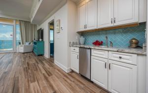 eine Küche mit weißen Schränken und Massivholzböden in der Unterkunft Phoenix Orange Beach 2204 condo in Orange Beach