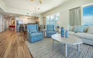 ein Wohnzimmer mit Sofa, Stühlen und einem Tisch in der Unterkunft Phoenix Orange Beach 2204 condo in Orange Beach