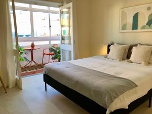 a bedroom with a large bed and a balcony at Apartamento a 400 metros da praia Santa Cruz in Santa Cruz