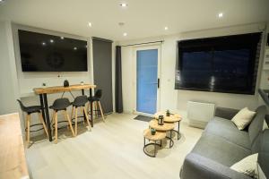 a living room with a couch and a table at Le Carolo Ducal in Charleville-Mézières