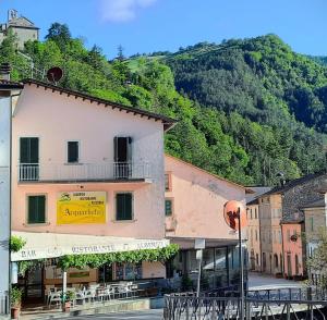 a group of buildings in a town with a mountain at Acquacheta Valtancoli Hotel B&B in San Benedetto in Alpe