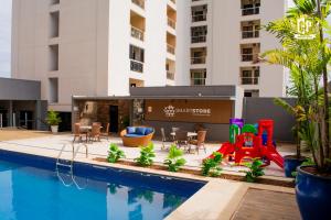 a hotel pool with a playground next to a building at Flat Crystal Place in Goiânia