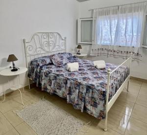 a bedroom with a bed and two tables and a window at Buenavista - CHC - Mar Azul in Buenavista del Norte