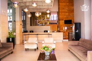 a lobby with a couch and chairs and a table at Flat Crystal Place in Goiânia
