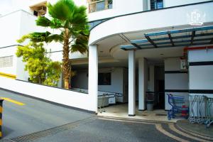 a gas station with a palm tree in front of it at Flat Crystal Place in Goiânia