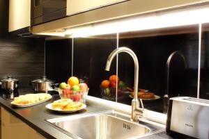 una encimera con fregadero y platos de fruta en Milford Suites Budapest, en Budapest