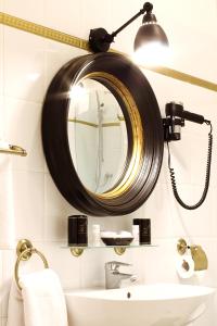 baño con espejo y lavabo en Milford Suites Budapest, en Budapest
